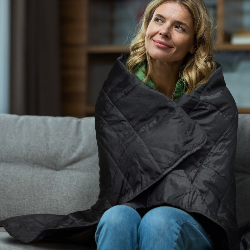 Cozy puffer blanket in stylish design, perfect for indoor and outdoor use, packed in a convenient drawstring pouch.