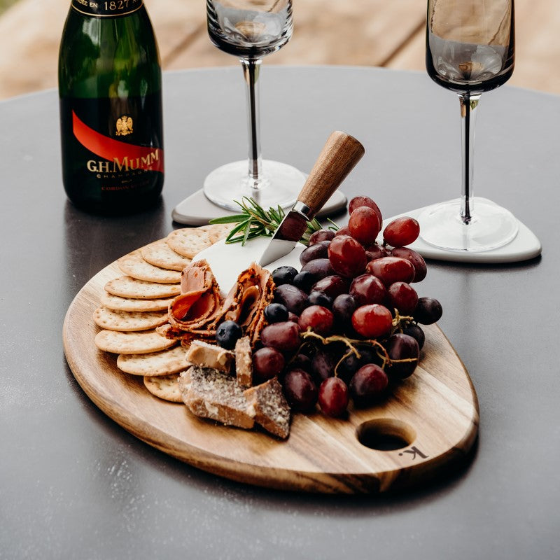 Natural acacia wood cheese serving board with polished surface, ideal for presenting cheeses and appetizers in style.