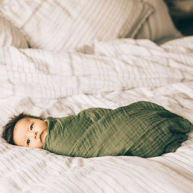 Lightweight cotton muslin swaddle in fern print, perfect for swaddling and promoting safe sleep for infants.