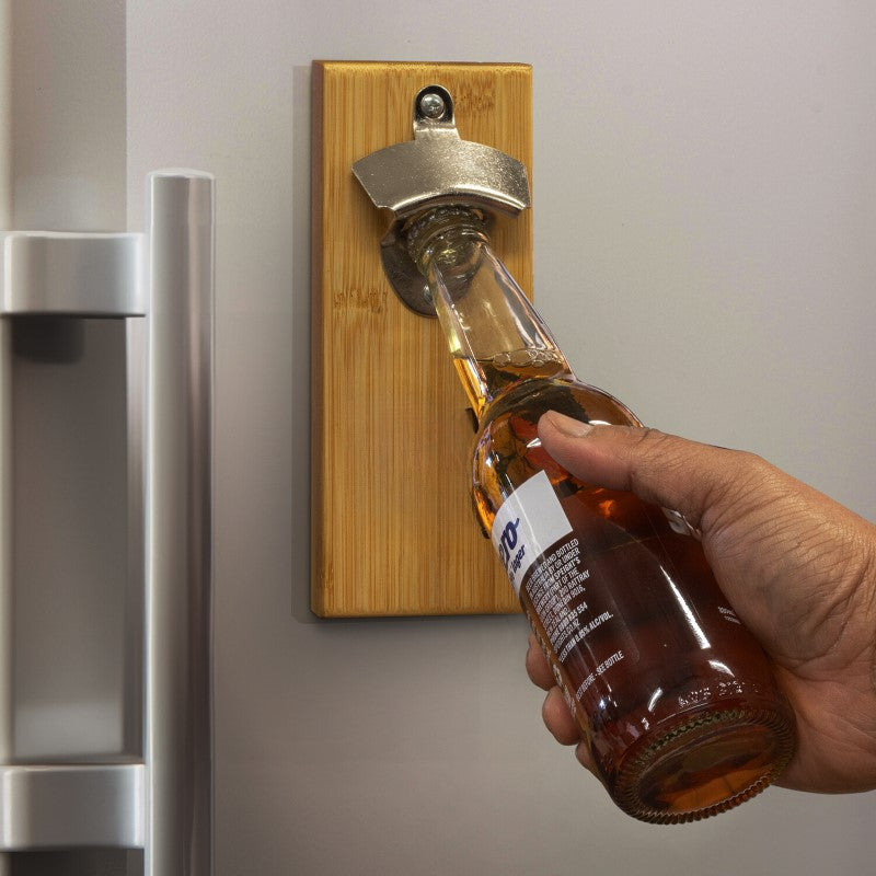 Magnetic fridge bottle opener with cap-catcher, bamboo backing, and durable iron; perfect for stylish kitchen convenience.