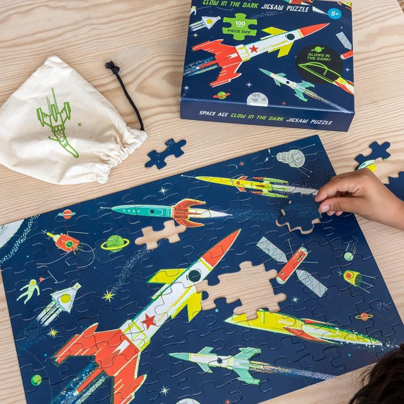 Colorful glow-in-the-dark space puzzle featuring rockets, planets, and stars; perfect for kids 5 and up.