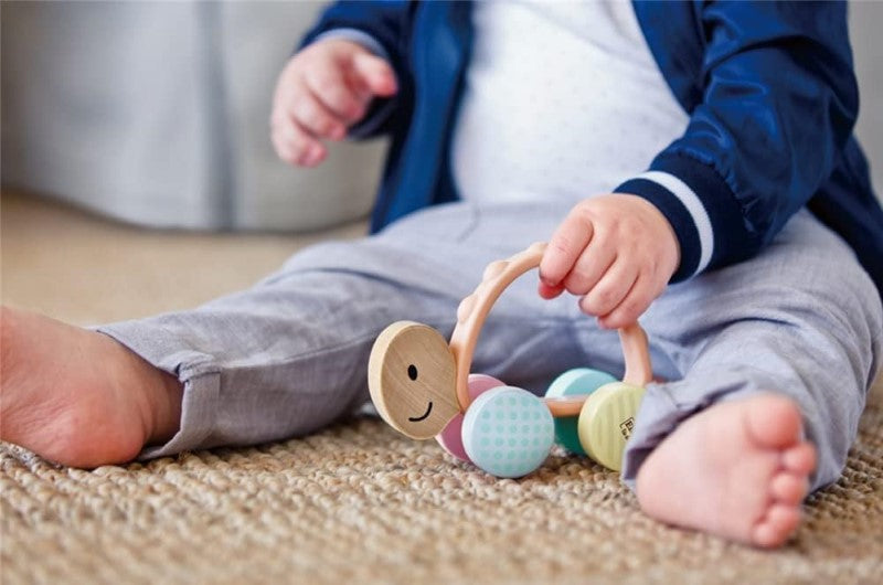 Colorful Wooden Turbo Turtle toy with patterned wheels and a silicone handle, designed for toddlers' interactive play and exploration.