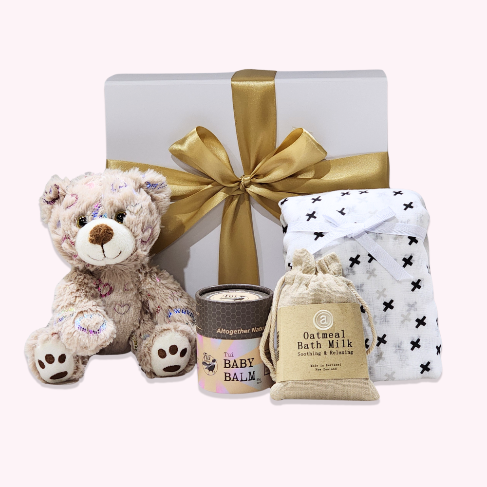Cuddly Baby gift box featuring a teddy bear, soothing bath milk, muslin blanket, and baby balm for new parents.