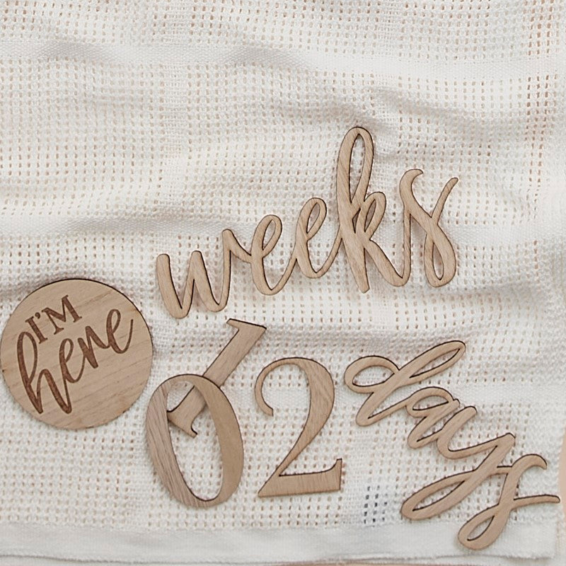 Wooden milestone sign kit with 17 pieces to celebrate baby's growth from pregnancy to first year milestones.