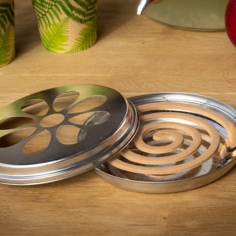 Citronella coils in a zinc burner elevate outdoor spaces by repelling insects with a natural, pleasant scent.