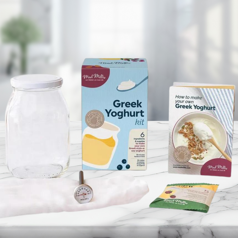 Mad Millie Greek Yoghurt Making Kit with cultures, jar, thermometer, and instructions for homemade yogurt varieties.