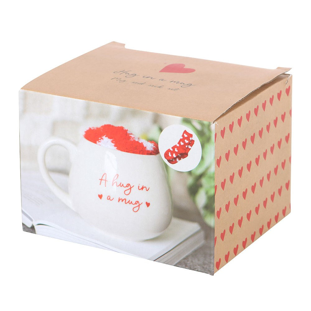 Gift set with a heart mug featuring 'Hug in a Mug' and cozy heart-patterned socks, perfect for warm drinks and comfort.