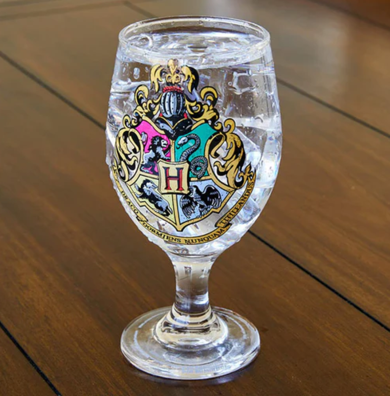 Hogwarts glass featuring the crest and color-changing effects with house colors when filled with cold beverages.