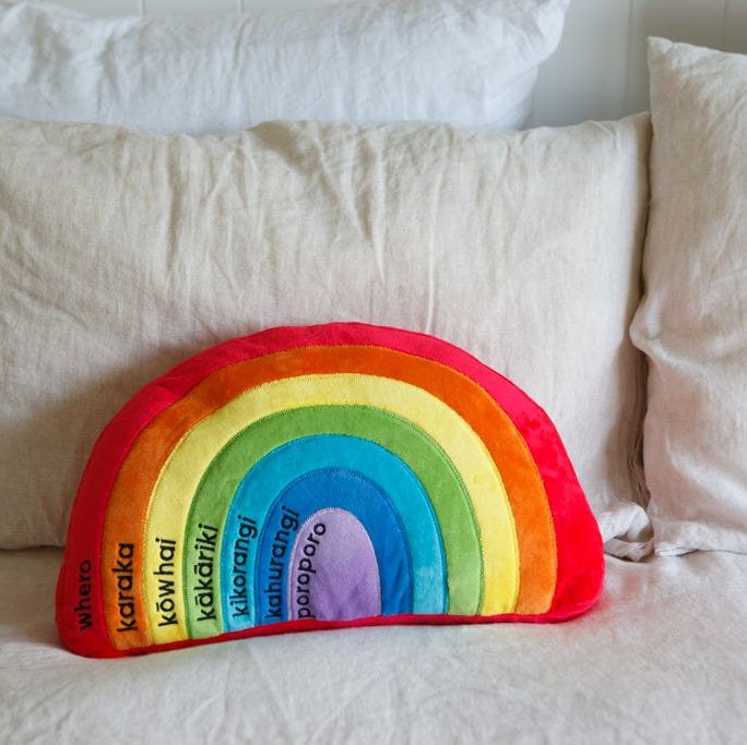 Soft rainbow cushion in Te Reo, ideal for colorful decor and teaching M?ori language to young learners.