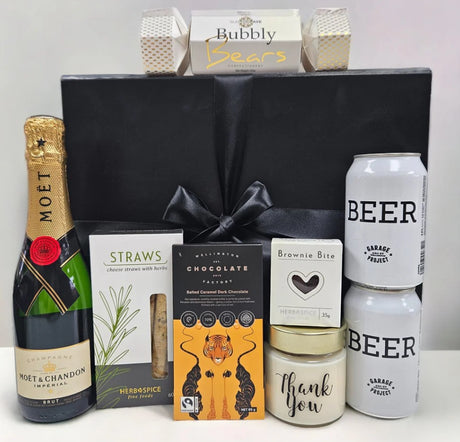 Elegant gift box containing Moet Champagne, craft beers, gourmet chocolates, a candle, and more, perfect for expressing gratitude.