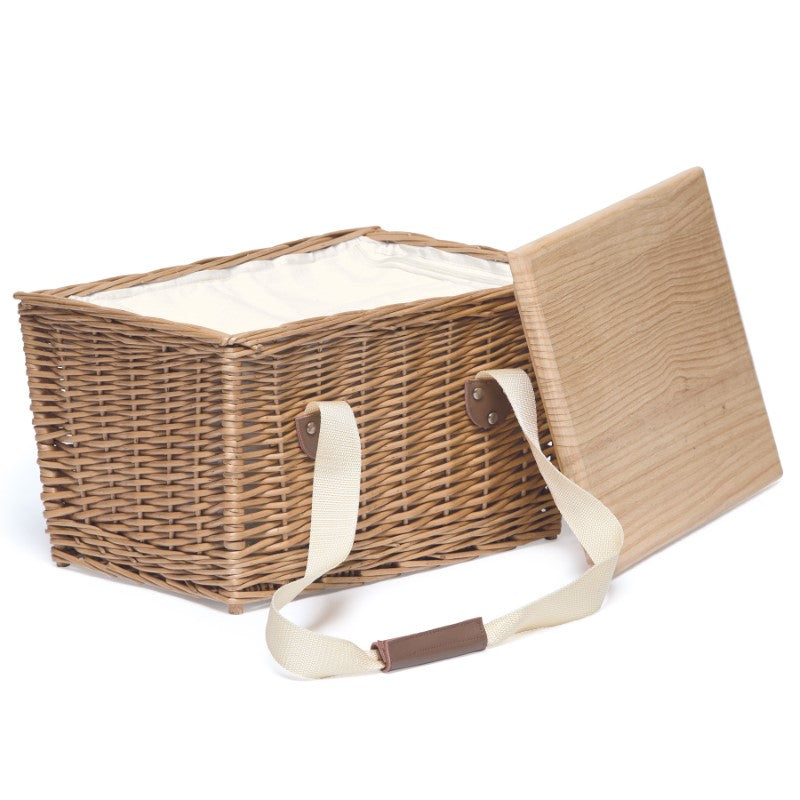 Wicker picnic basket with removable serving lid, insulated cooler, leather handles, and zippered canvas cover for outdoor use.