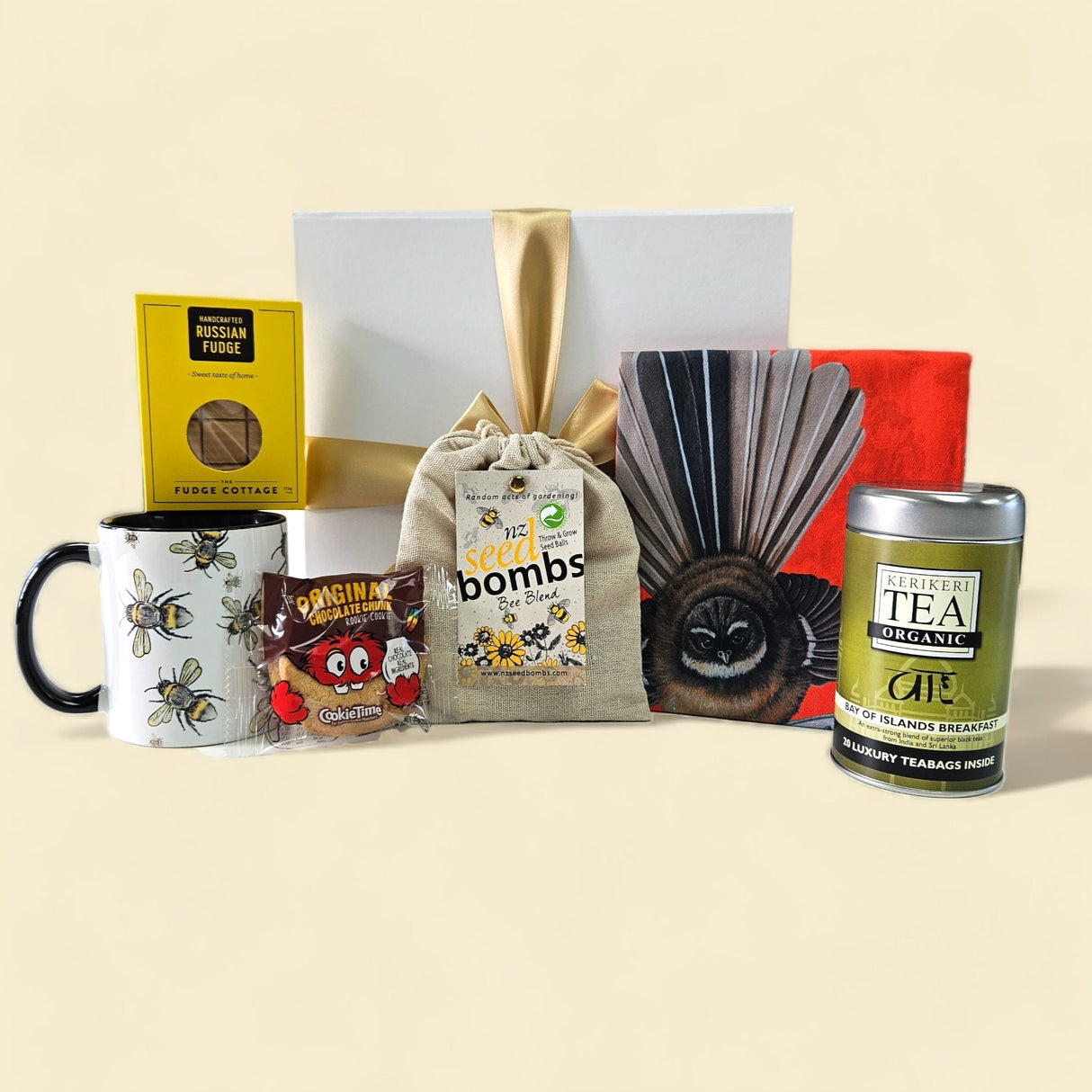 Elegant gift box featuring tea, eco-friendly seed bombs, a bee mug, and treats, perfect for tea lovers and gardeners.