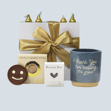 "Elegant gift box filled with thoughtful items like a planter, fudge, brownies, and chocolates to express gratitude."