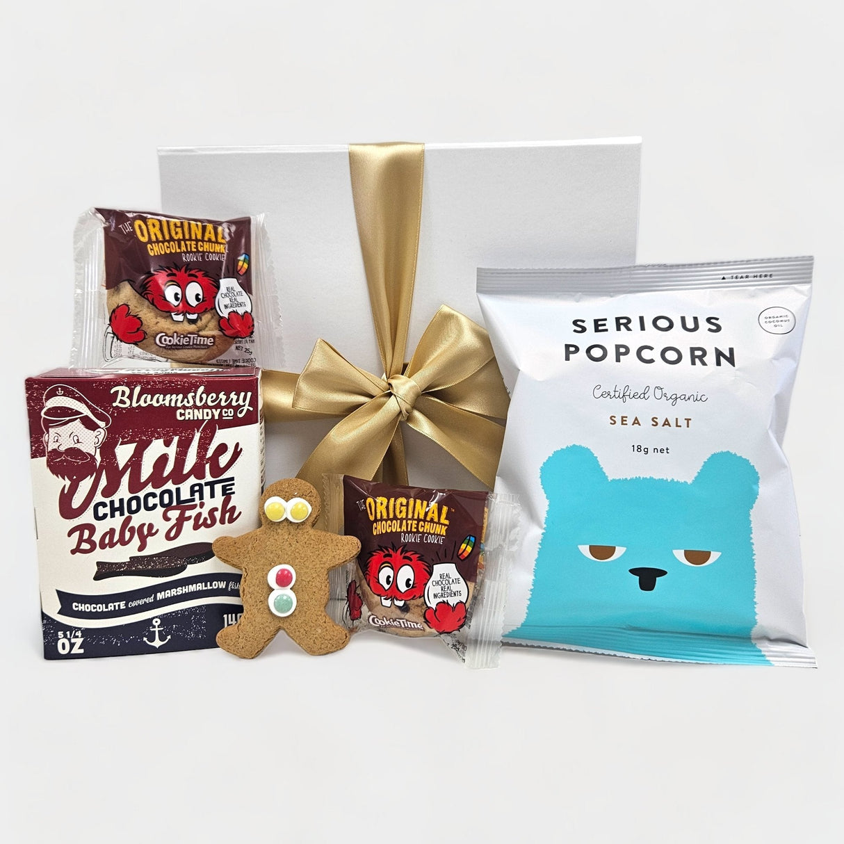 Colorful gift box filled with sweet treats for kids, including popcorn, cookies, and chocolate fish, perfect for celebrations.