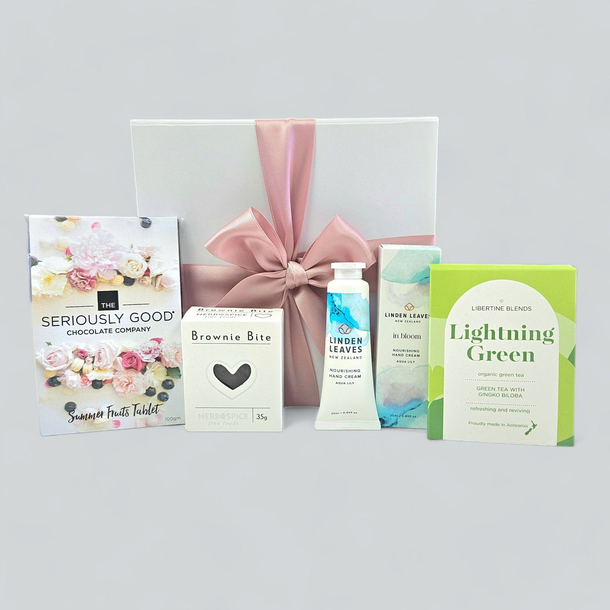 Charming green gift box filled with treats like brownies, chocolate, hand cream, and tea, ideal for any celebration.
