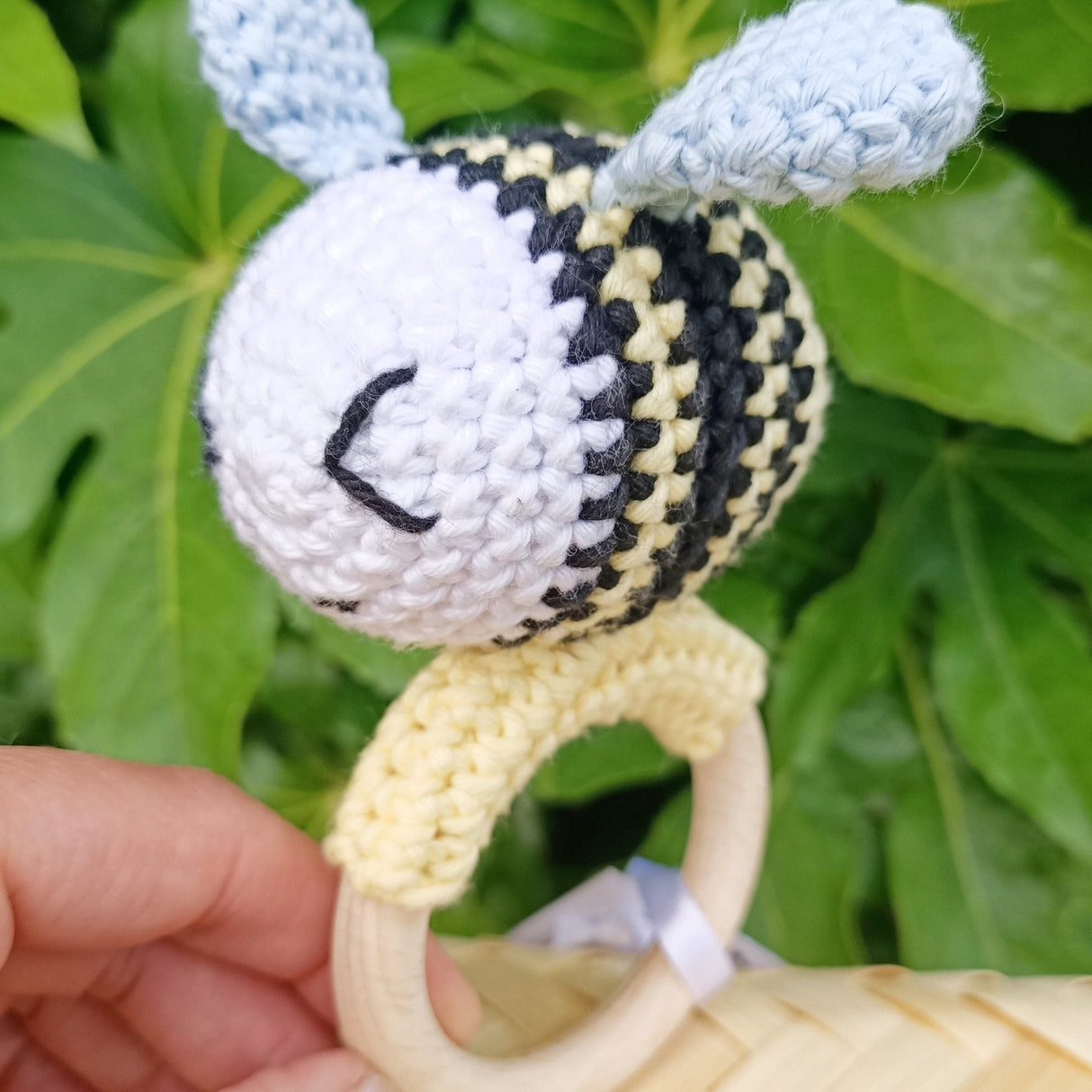 Bee-shaped rattle/teether with cotton exterior, beechwood ring, and sensory-friendly design, handmade in New Zealand.