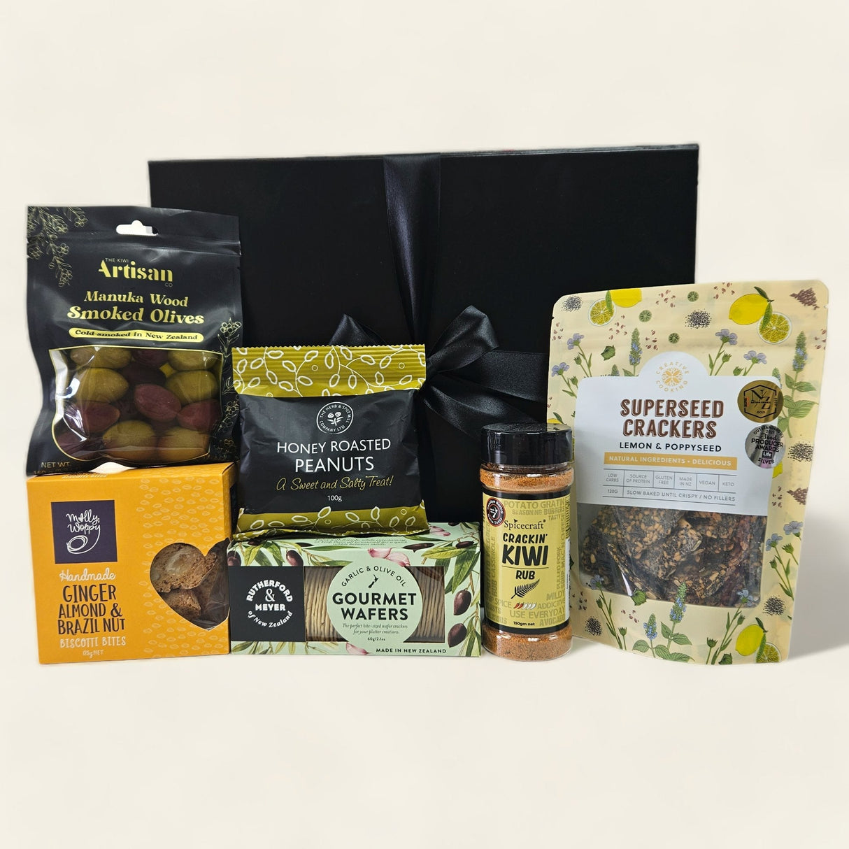 Gift box filled with savoury treats including roasted peanuts, gourmet wafers, olives, biscotti, rub, and crackers.