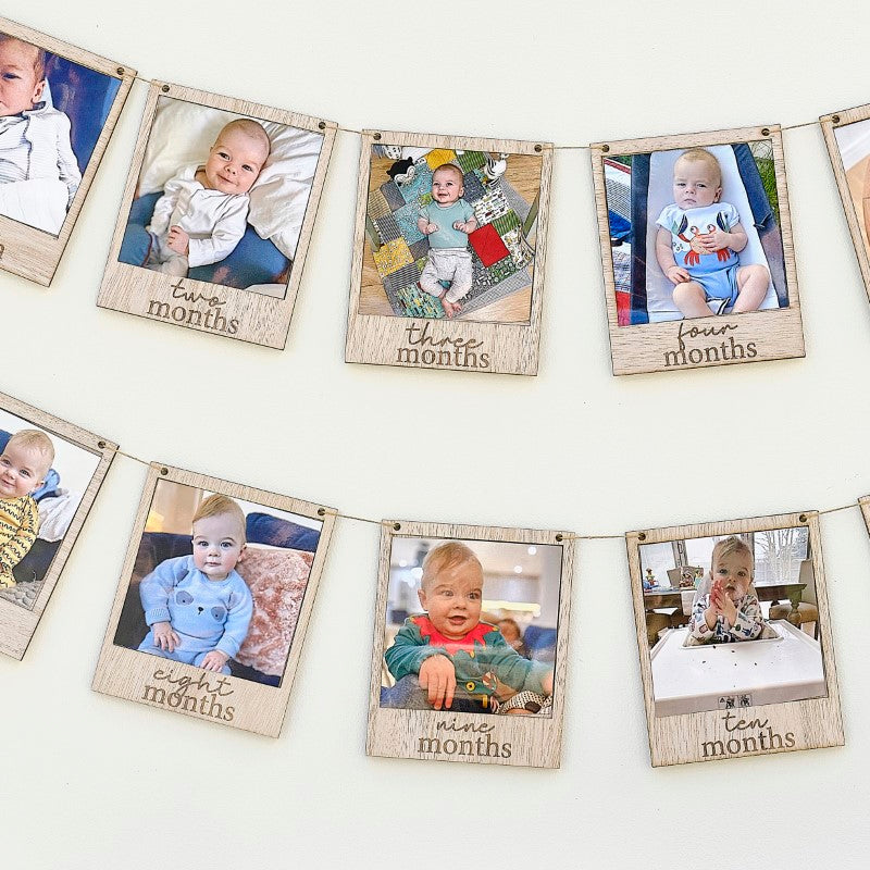 Wooden Baby Photo Bunting with 12 frames on twine, perfect for celebrating milestones and displaying cherished photos.