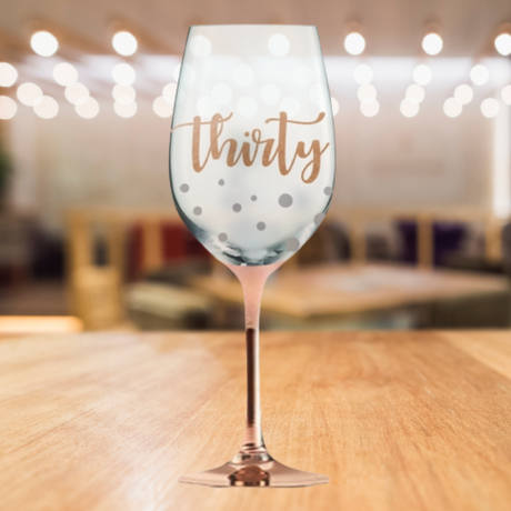 Hand-painted rose gold stem wine glass with '30 Happy Birthday' script, perfect for celebrating a milestone birthday in style.