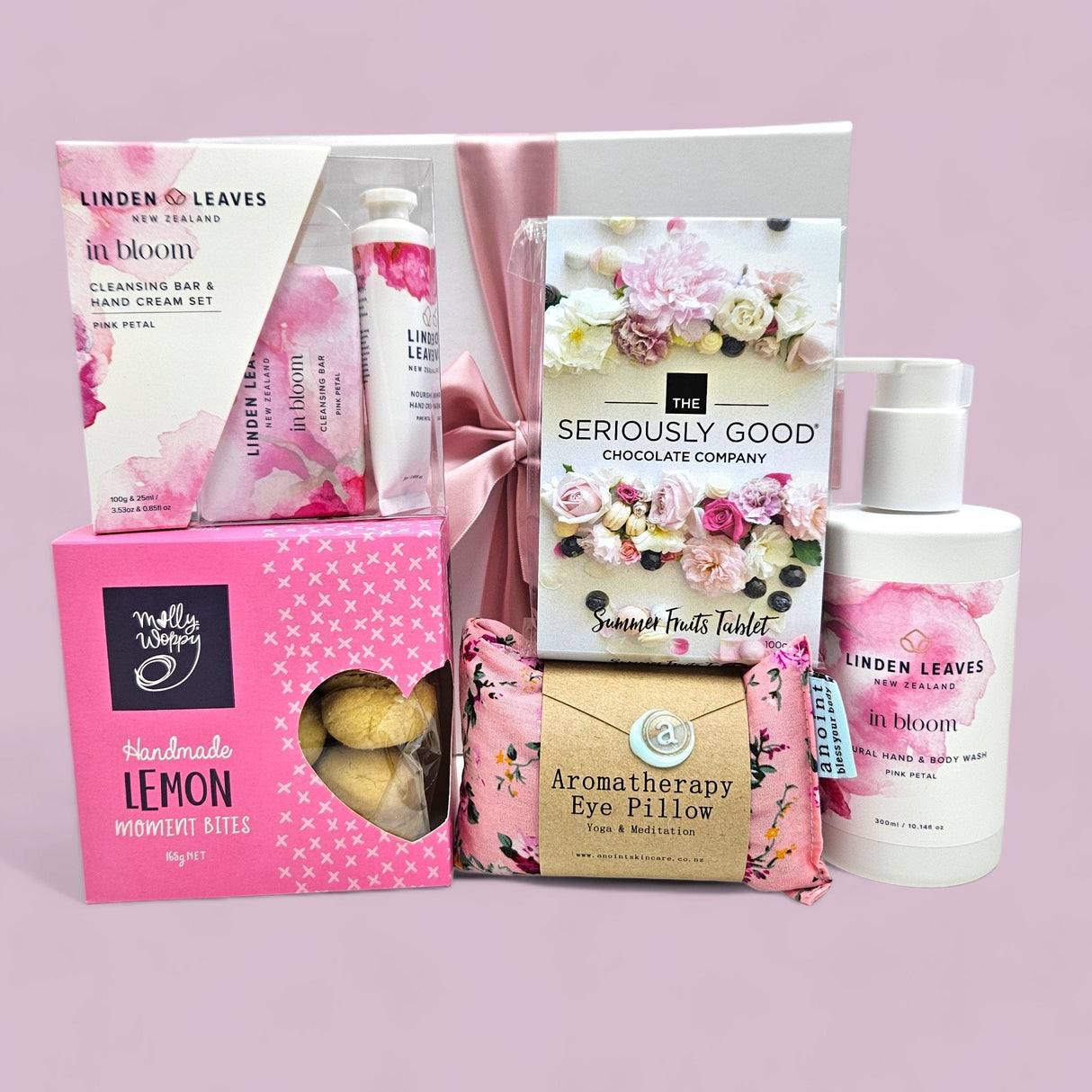 Luxurious gift box featuring hand cream, aromatherapy eye pillow, gourmet treats, and a ribbon for special occasions.