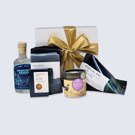 Elegant gift box featuring artisan gin, soothing balm, natural soap, bath bomb, eco-friendly facecloths, and a luxurious presentation.