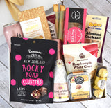 Cheers & Treats Gift Box featuring gourmet snacks and premium beverages, elegantly packaged with a gold bow.