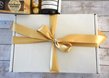 Gift box featuring two premium wines and gourmet treats, elegantly packaged with a gold bow for special celebrations.