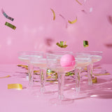 Prosecco Pong game set featuring 12 glasses and 3 pink ping pong balls for elegant party fun and celebrations.