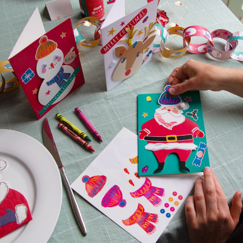 Children's Christmas Card Making Kit with stickers, pom poms, and festive cut-outs for creative holiday card crafting.