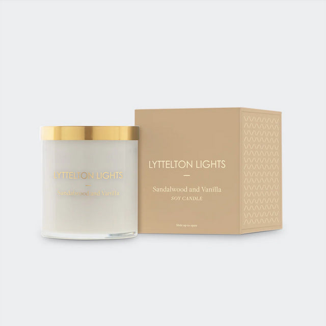 Lyttelton Lights Sandalwood & Vanilla Candle in a glass jar, showcasing a warm glow with a blend of woody and sweet fragrances.