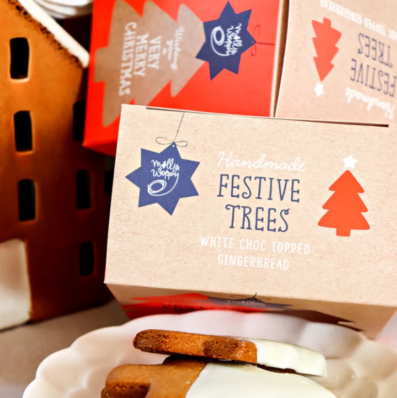 Molly Woppy Gingerbread Festive Tree Cookies shaped like Christmas trees, dipped in white chocolate, perfect for holiday gifting.