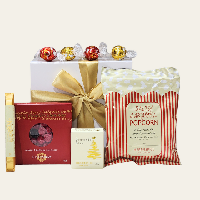 A festive gift box filled with gourmet treats, including chocolates, popcorn, brownies, and fruity gummies for holiday joy.