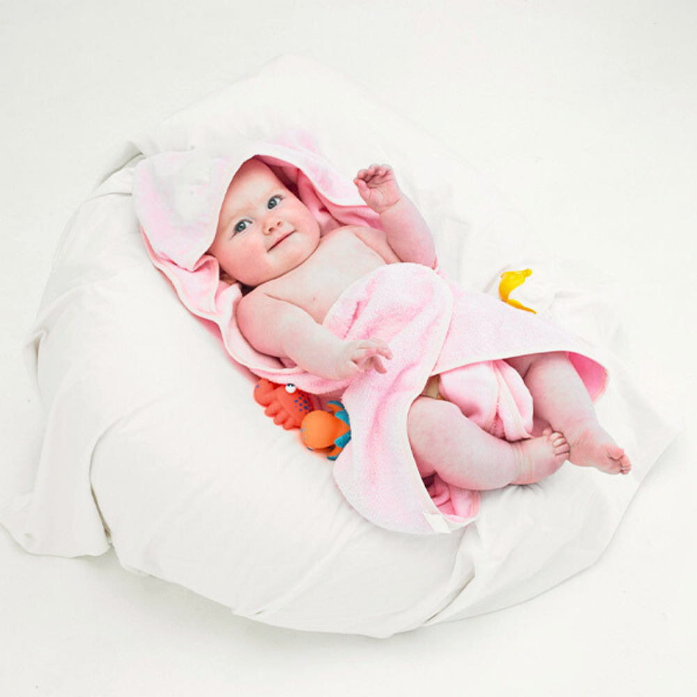 Soft pink baby hooded towel made of 100% cotton, designed for warmth and absorbency after bath time.