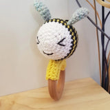 Bee-shaped rattle and teether made of cotton and beechwood, perfect for sensory play and teething relief.