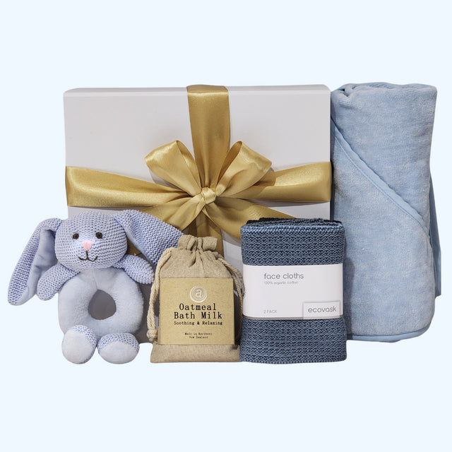 Azure Baby Essentials gift set featuring a hooded towel, bunny rattle, bath milk, and soft facecloths for newborn comfort.