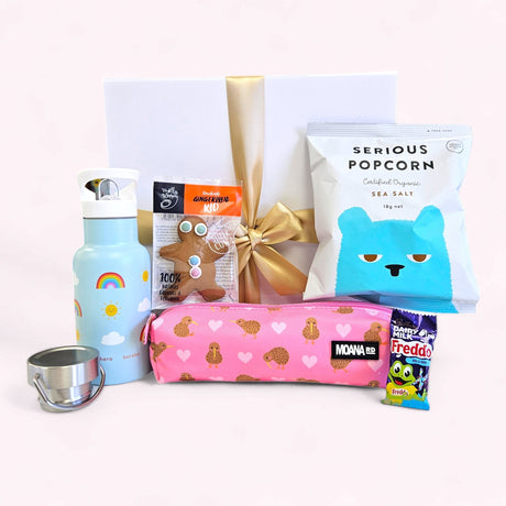 Gift box for kids in pink, featuring snacks, a pencil case, a drink bottle, and a ribbon closure, perfect for any occasion.