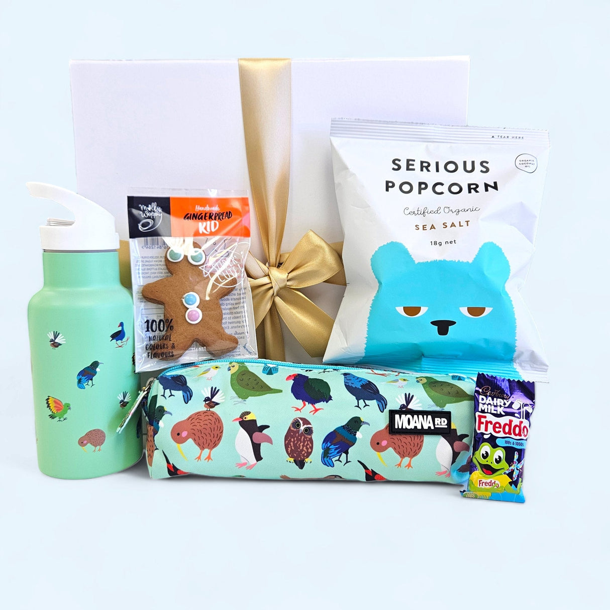 Colorful gift box filled with children's treats, including popcorn, biscuits, and fun school supplies. Perfect for any occasion.