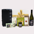 A luxury picnic set featuring wine, gourmet snacks, a stylish blanket, and chocolate, elegantly packaged in a gift box.