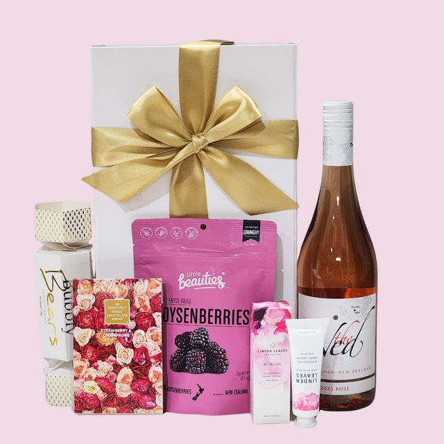 Elegant gift box with premium pink-themed products, including wine, treats, chocolate, and hand cream for any occasion.